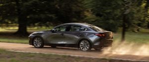 A charcoal 2020 Mazda3 being driven on a dirt road. | Mazda dealer in St. Louis, MO