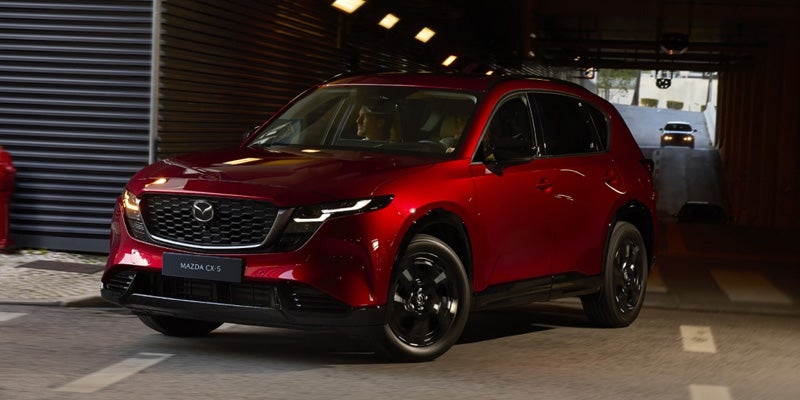 Red Mazda CX-5 parked near a garrage